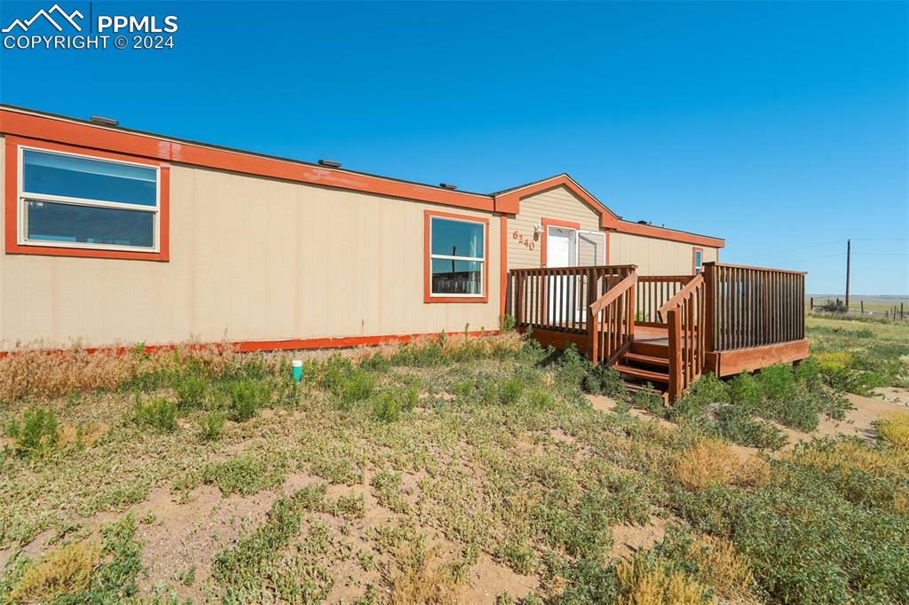 6240 Night Train Lane Yoder, CO 80864 - Photo 8 of 50 a backyard of a house with barbeque oven and wooden fence