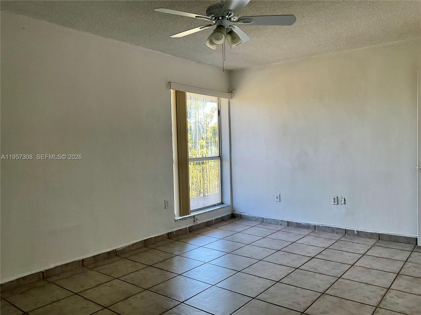 1910 West 56th Street, Unit 3302 Hialeah, FL 33012 - Photo 11 of 19 an empty room with a chandelier fan and windows