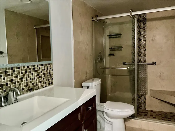 a bathroom with a sink a toilet and shower