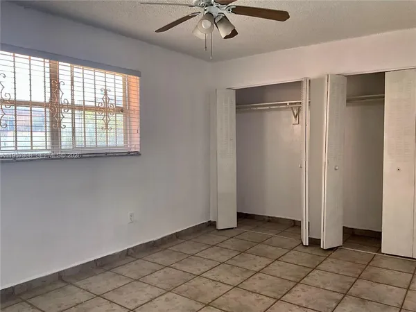 an empty room with chandelier fan