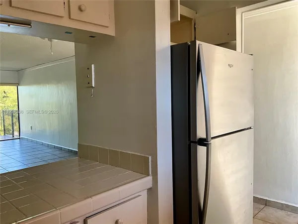 an empty room with a ceiling fan and carpet