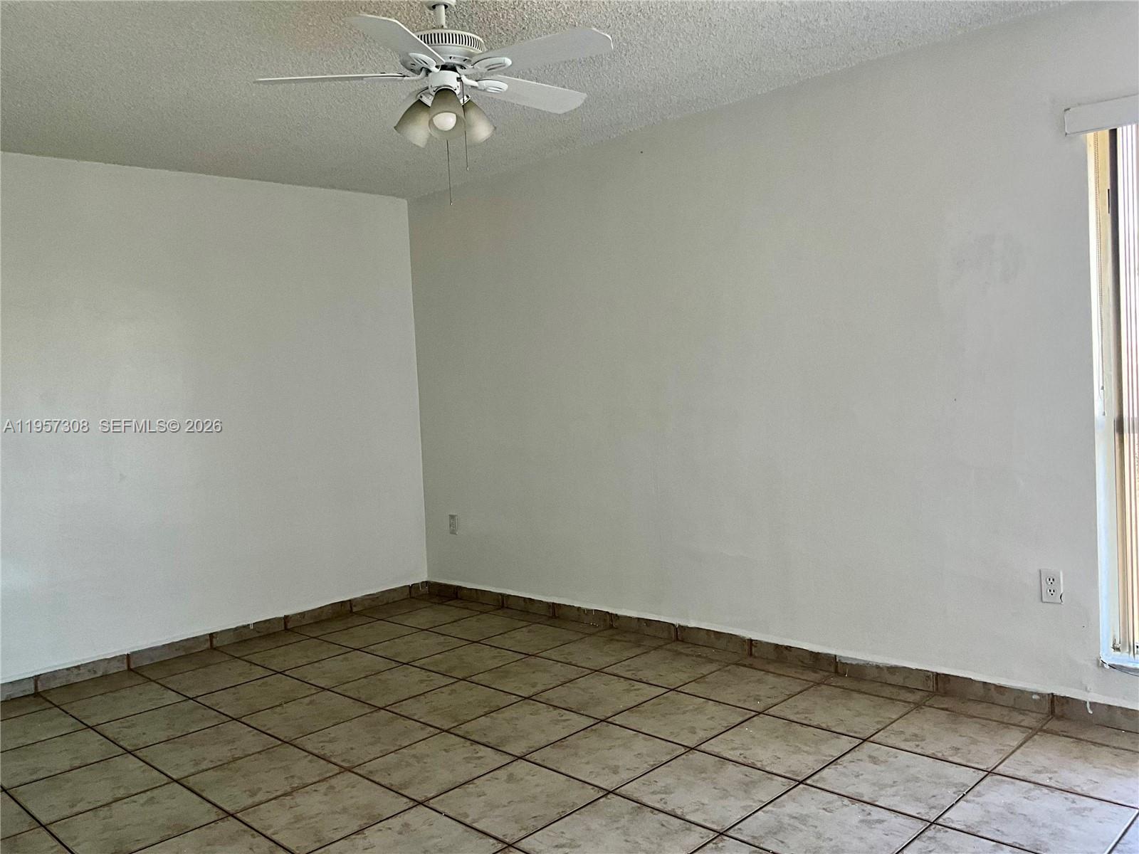 1910 West 56th Street, Unit 3302 Hialeah, FL 33012 - Photo 10 of 19 an empty room with a ceiling fan and carpet