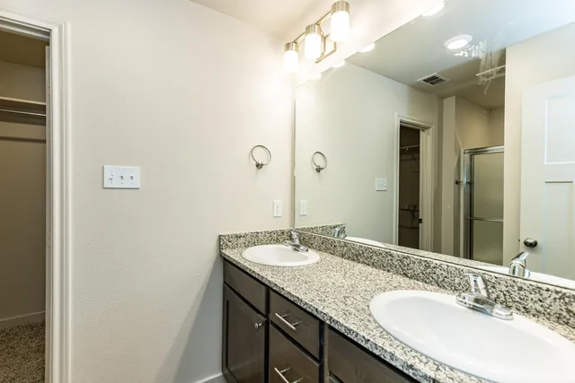 a bathroom with a granite countertop sink and a mirror