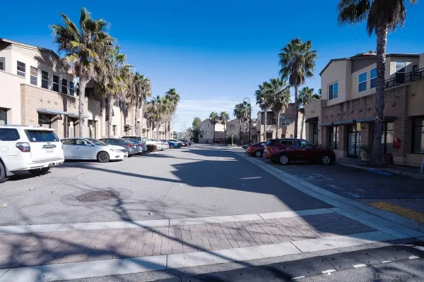 a city street lined with buildings and cars parked on the roadside