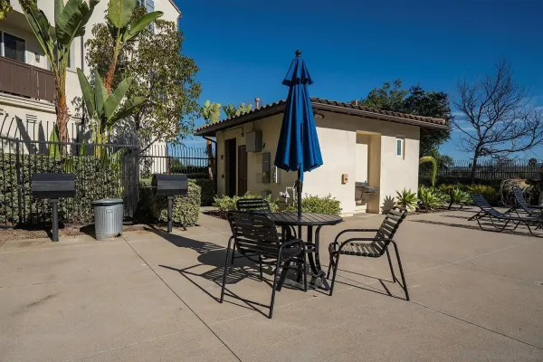 a view of a patio with table and chairs with wooden fence and plants