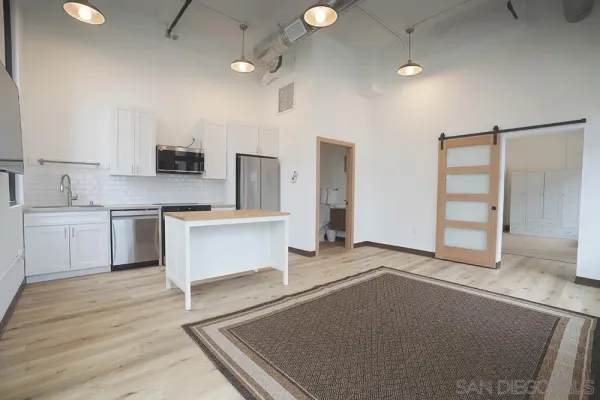 a large white kitchen with a refrigerator a stove top oven a sink and dishwasher