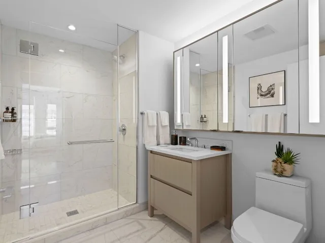 a bathroom with a toilet a sink and shower