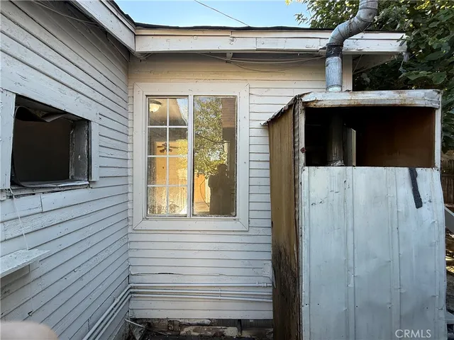 a view of a house with a door and a car parked side of it