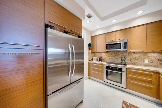 a kitchen with stainless steel appliances granite countertop a sink a stove and a microwave