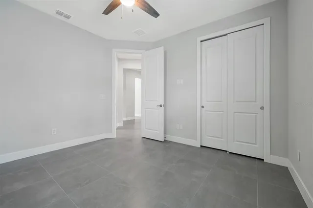 an empty room with chandelier fan