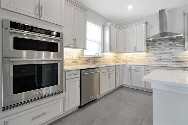 a kitchen with cabinets stainless steel appliances and sink