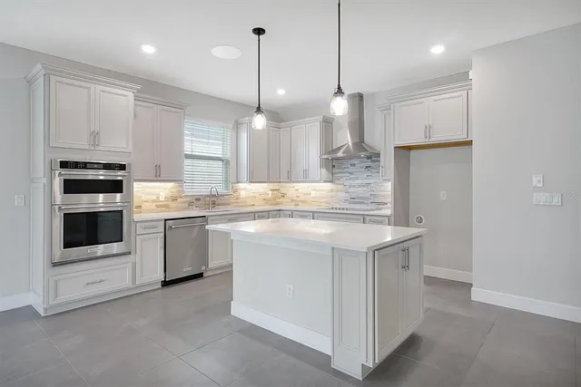 a kitchen with kitchen island granite countertop appliances cabinets and a counter top