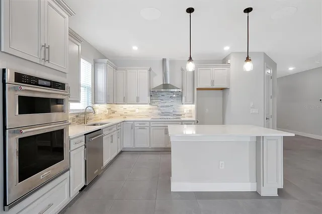 a kitchen with kitchen island white cabinets and stainless steel appliances