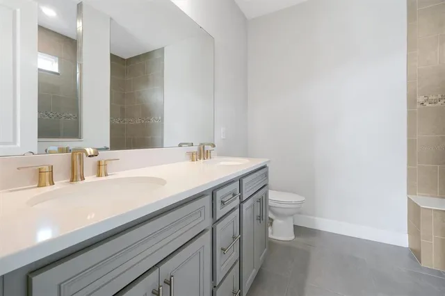 a bathroom with a sink a toilet and a mirror