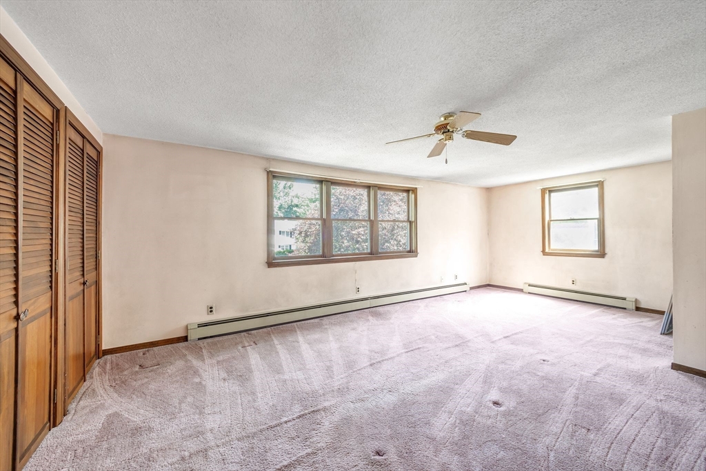 9 Bear Hill Road Billerica, MA 01821 - Photo 10 of 29 an empty room with chandelier fan and windows