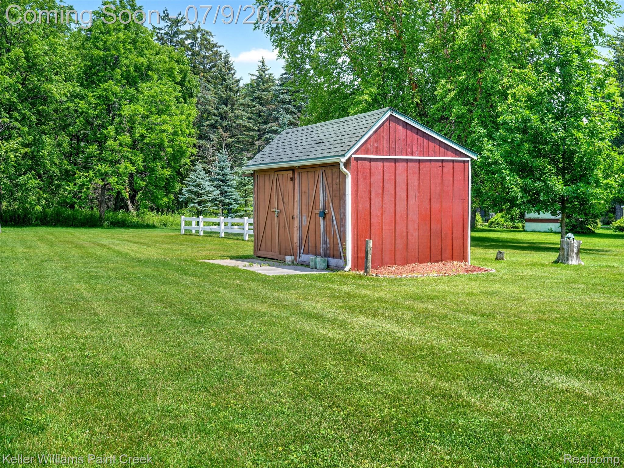 204 Russell Road Kawkawlin, MI 48631 - Photo 56 of 82 Detached red outbuilding with wood doors and a shingled roof, set on a concrete pad