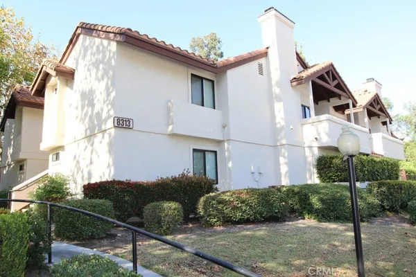 a view of a white house next to a yard