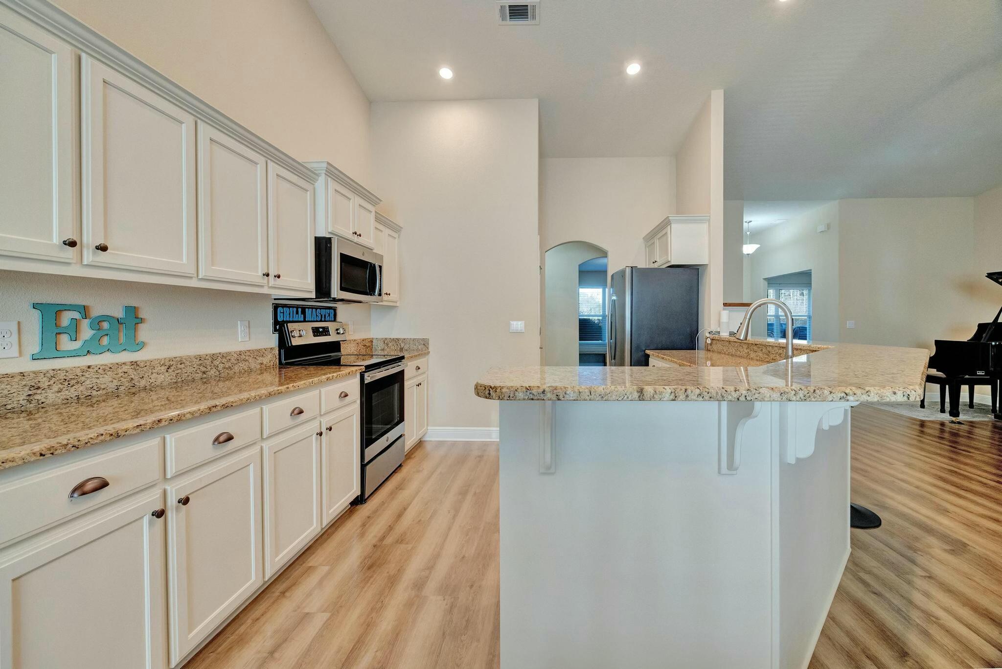 3278 Main Street Navarre, FL 32566 - Photo 12 of 43 a kitchen with stainless steel appliances granite countertop a sink and cabinets