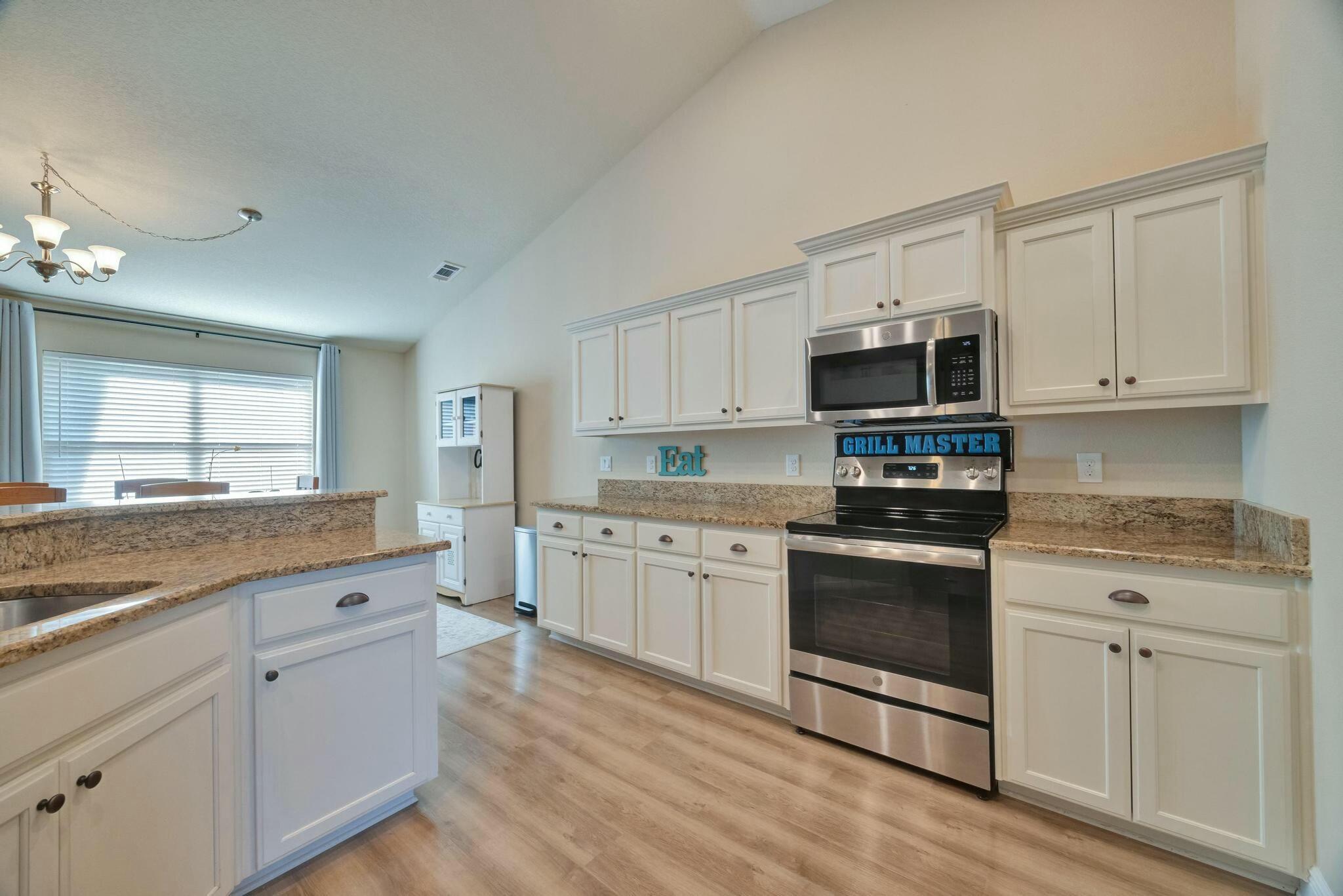 3278 Main Street Navarre, FL 32566 - Photo 15 of 43 a kitchen with granite countertop white cabinets and appliances
