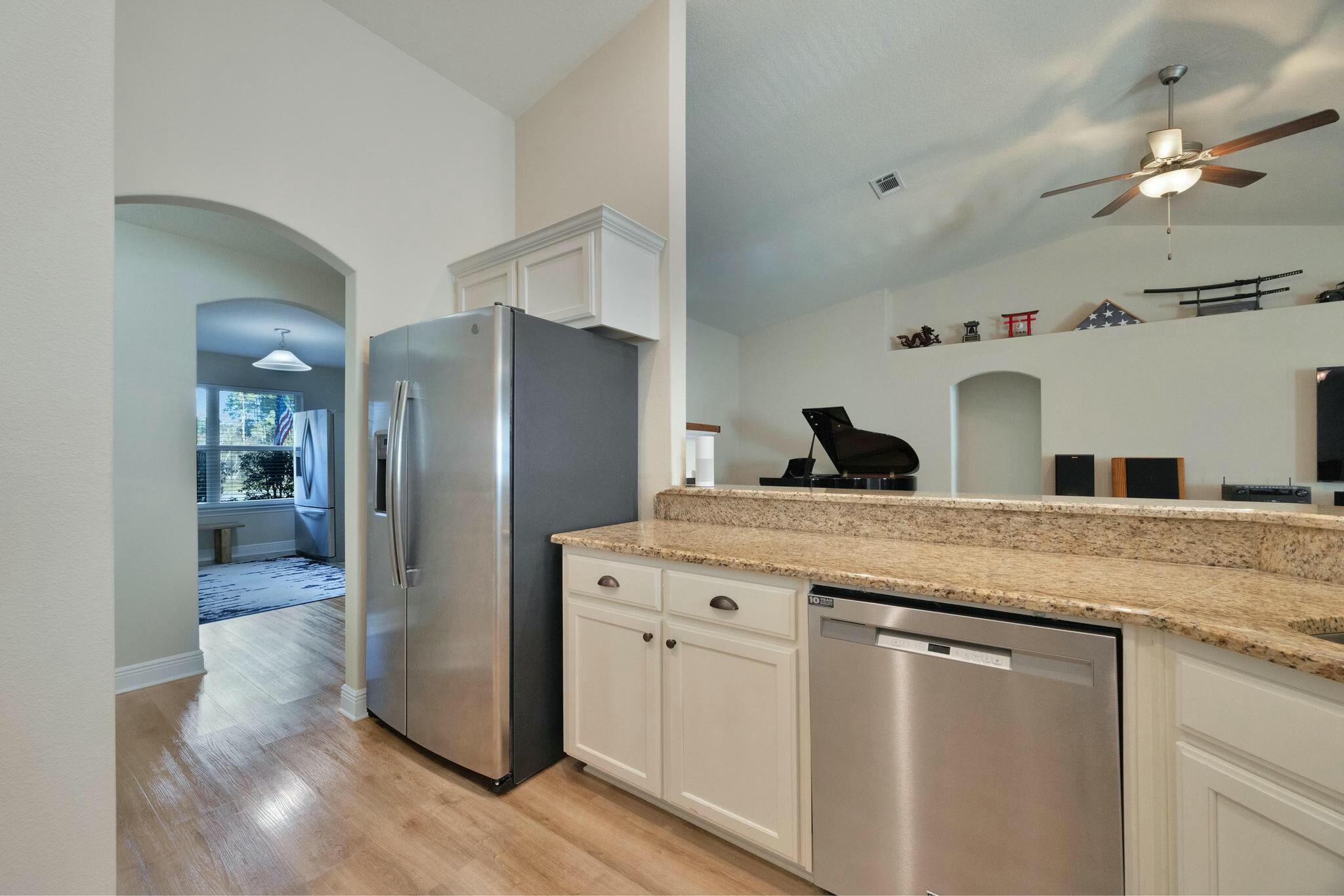 3278 Main Street Navarre, FL 32566 - Photo 16 of 43 a kitchen with granite countertop a refrigerator and a sink