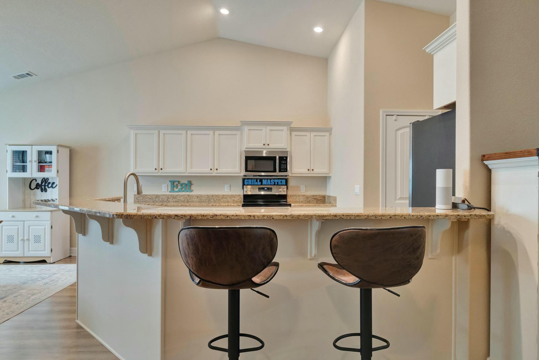 3278 Main Street Navarre, FL 32566 - Photo 17 of 43 a kitchen with stainless steel appliances granite countertop a stove a sink and a refrigerator