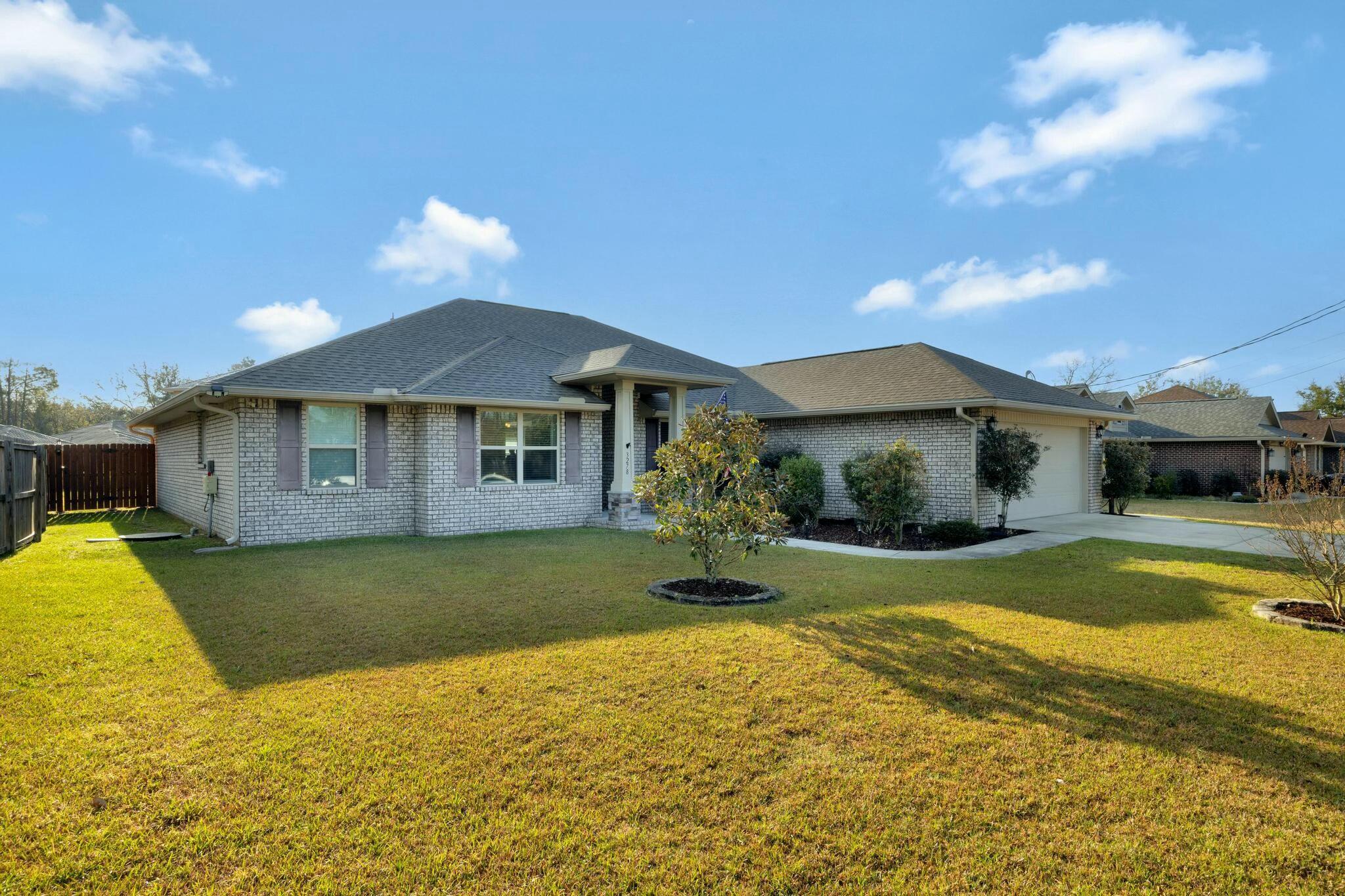 3278 Main Street Navarre, FL 32566 - Photo 2 of 43 a front view of a house with a yard