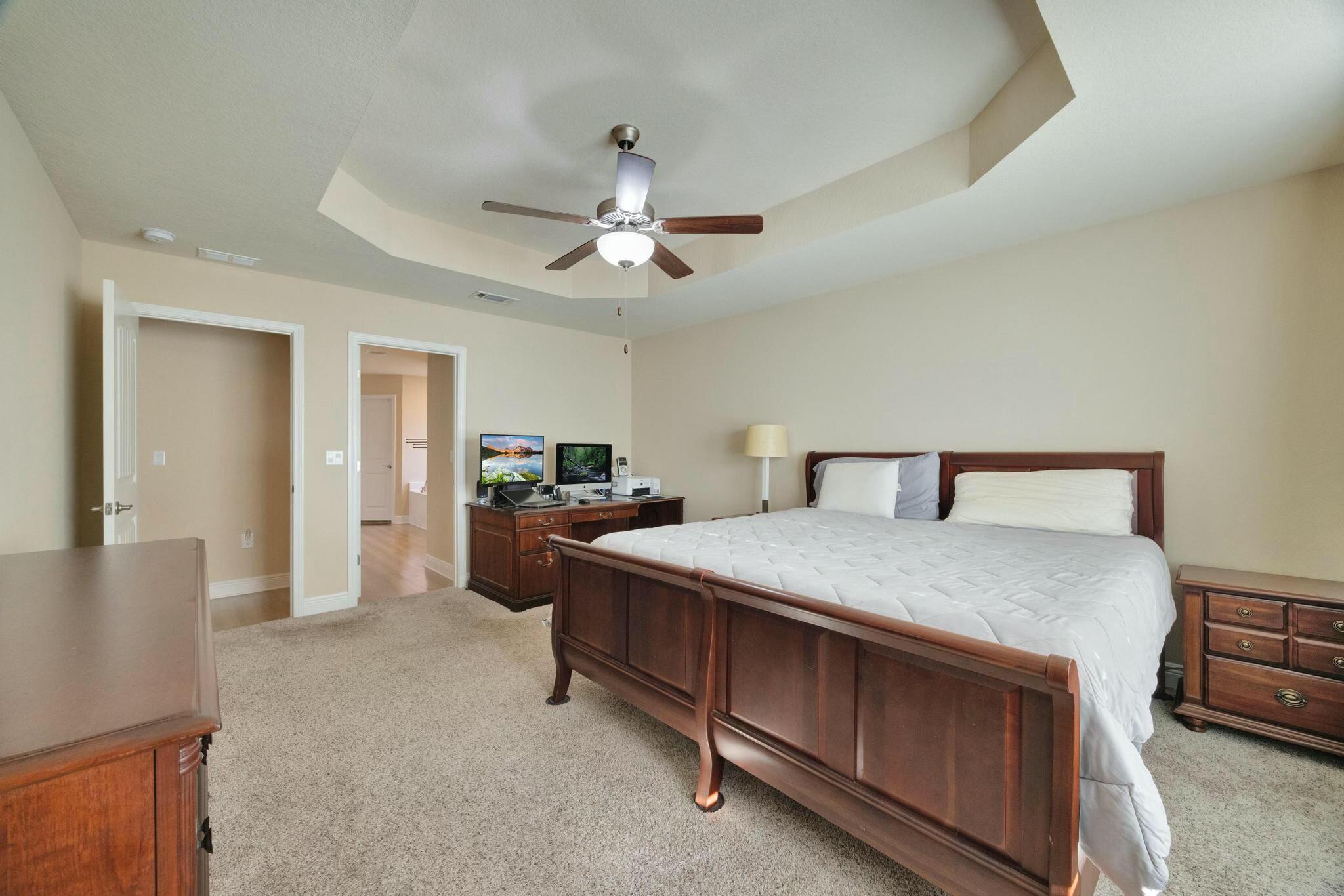 3278 Main Street Navarre, FL 32566 - Photo 21 of 43 a spacious bedroom with a bed and a chandelier