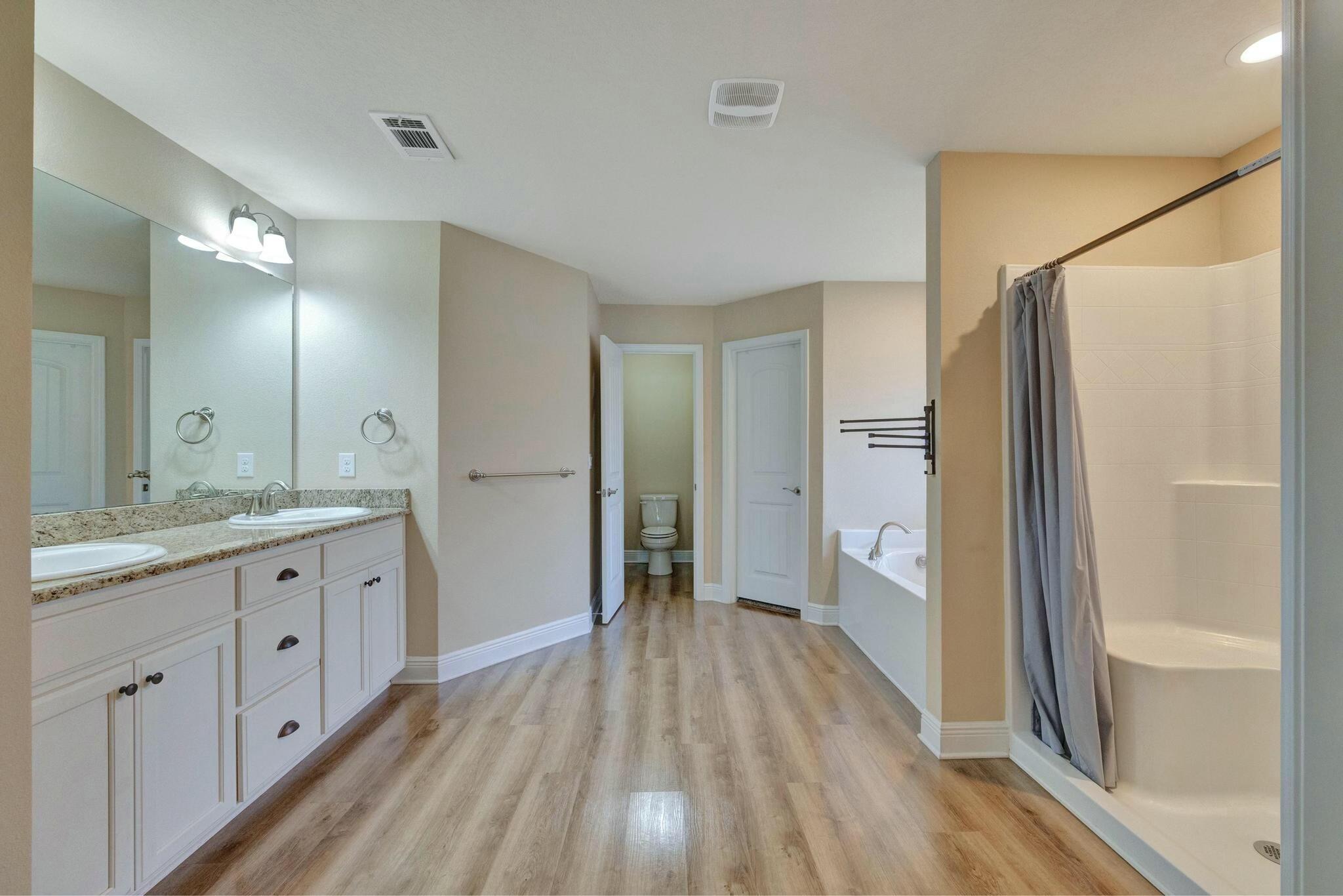 3278 Main Street Navarre, FL 32566 - Photo 22 of 43 a bathroom with a granite countertop shower a sink and a mirror
