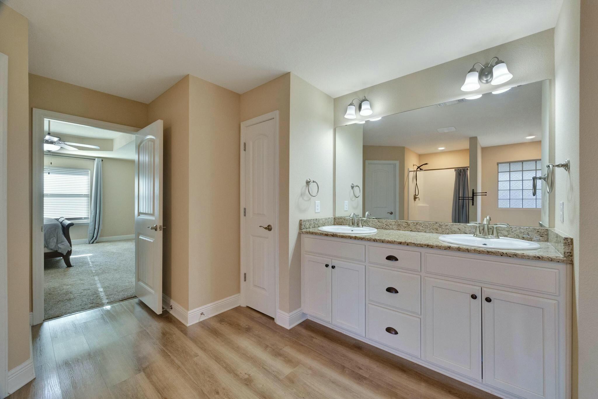 3278 Main Street Navarre, FL 32566 - Photo 23 of 43 a bathroom with a granite countertop sink mirror and vanity