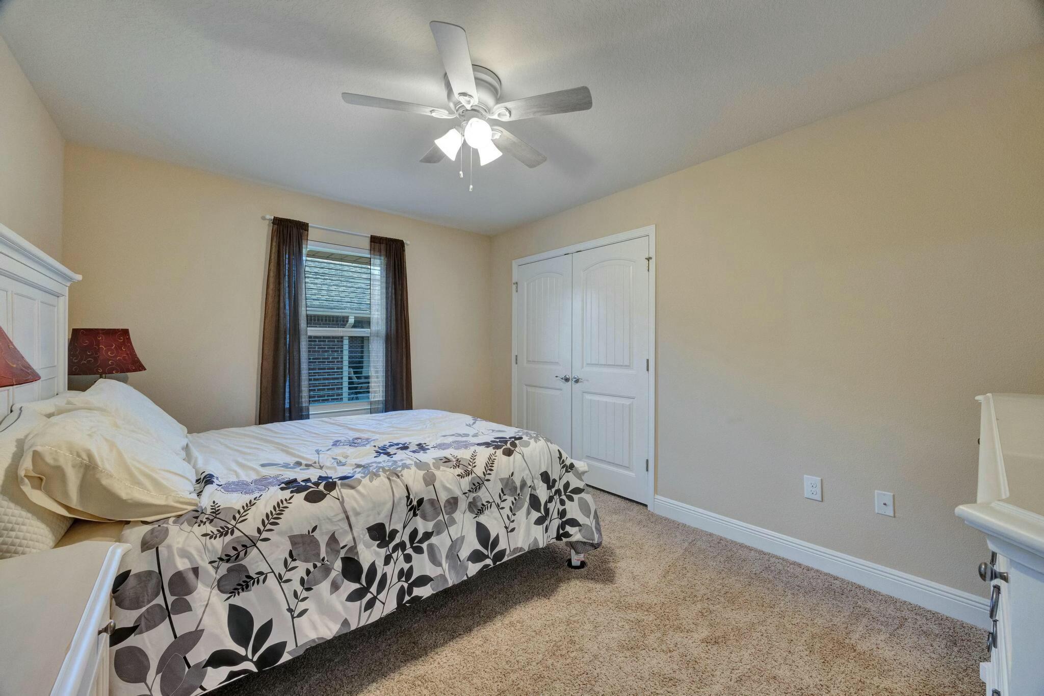 3278 Main Street Navarre, FL 32566 - Photo 28 of 43 a bedroom with a large bed and a chandelier