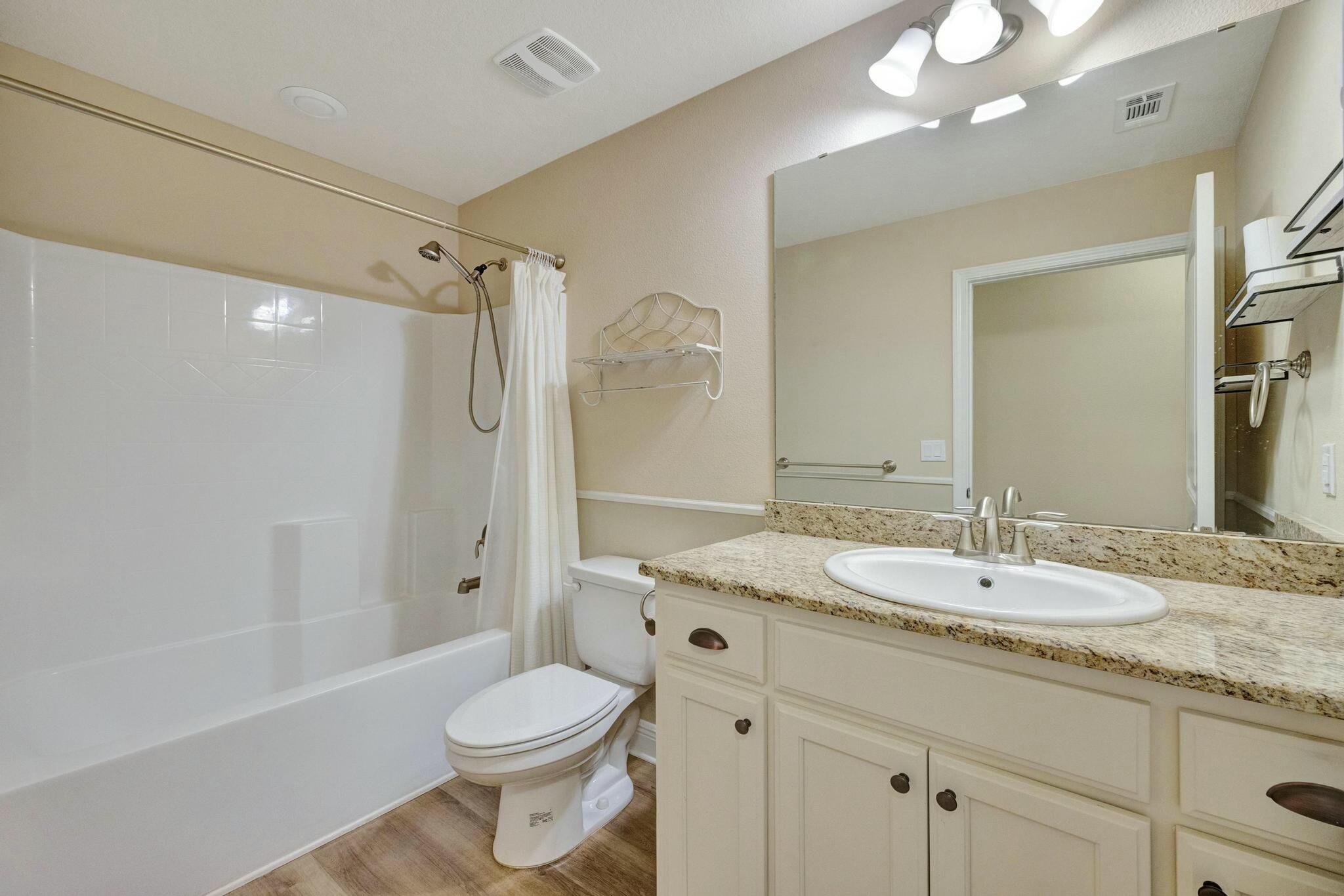 3278 Main Street Navarre, FL 32566 - Photo 30 of 43 a bathroom with a granite countertop sink toilet and shower