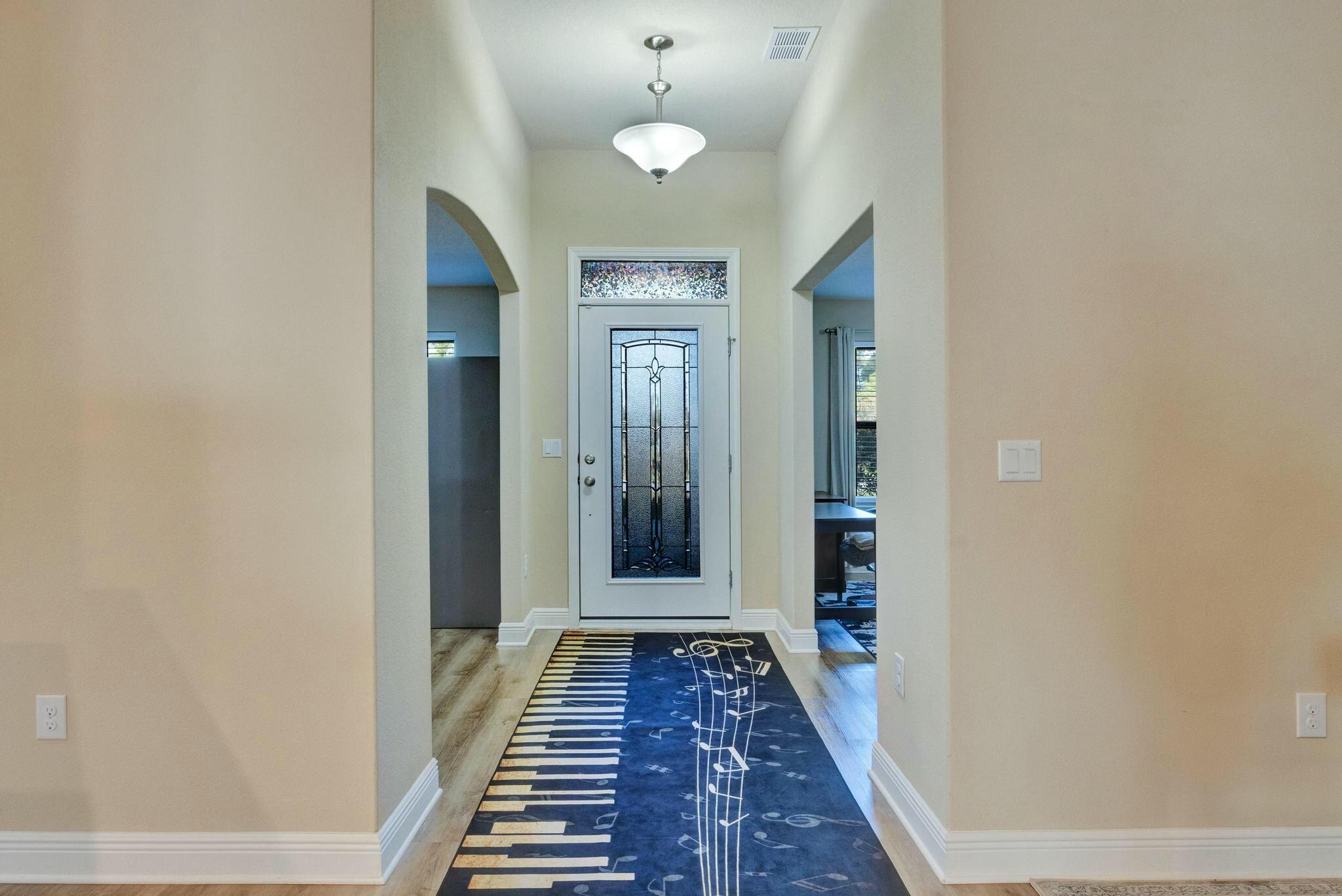 3278 Main Street Navarre, FL 32566 - Photo 4 of 43 a view of a hallway with wooden floor and a chandelier