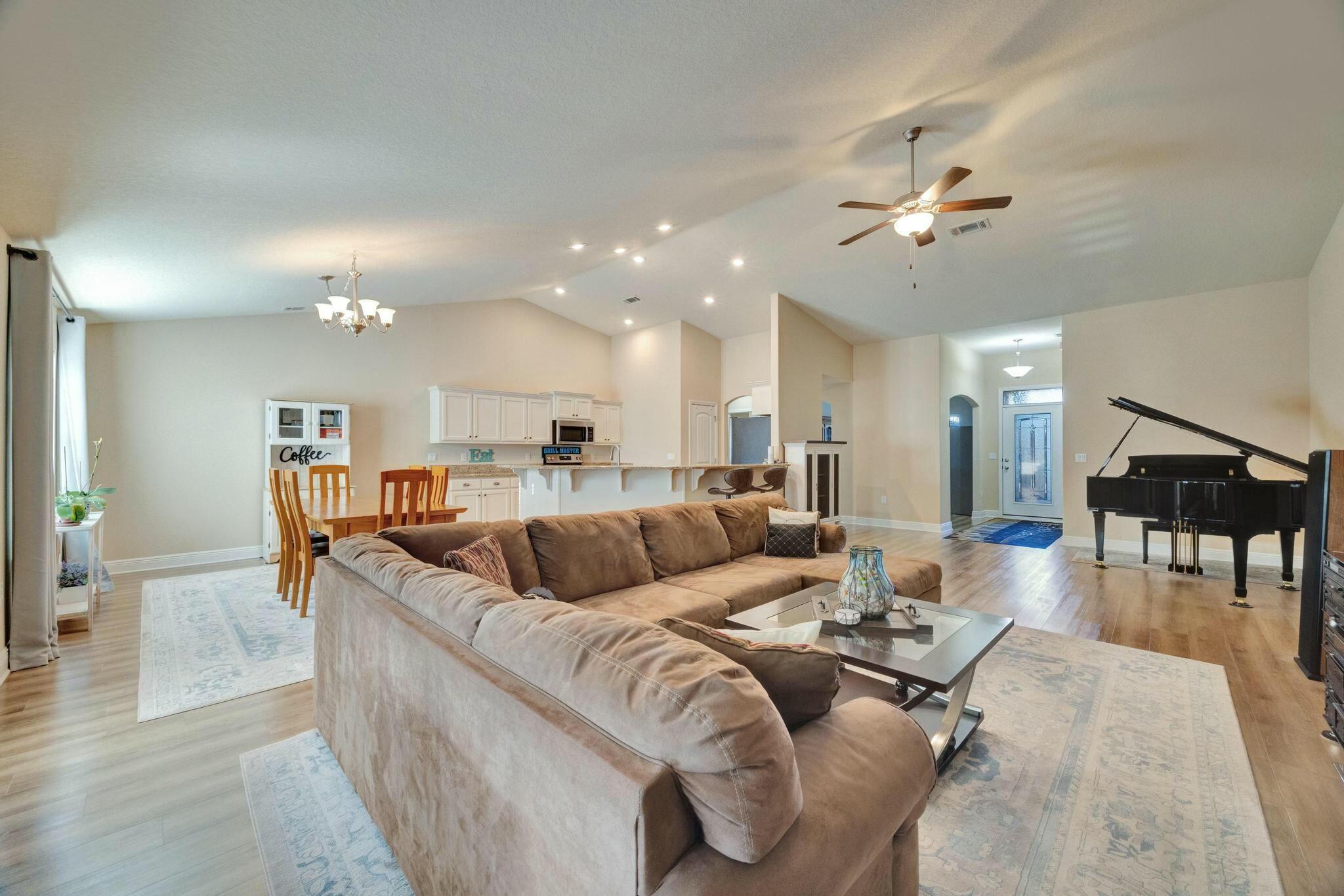 3278 Main Street Navarre, FL 32566 - Photo 7 of 43 a living room with furniture and a dining table with wooden floor