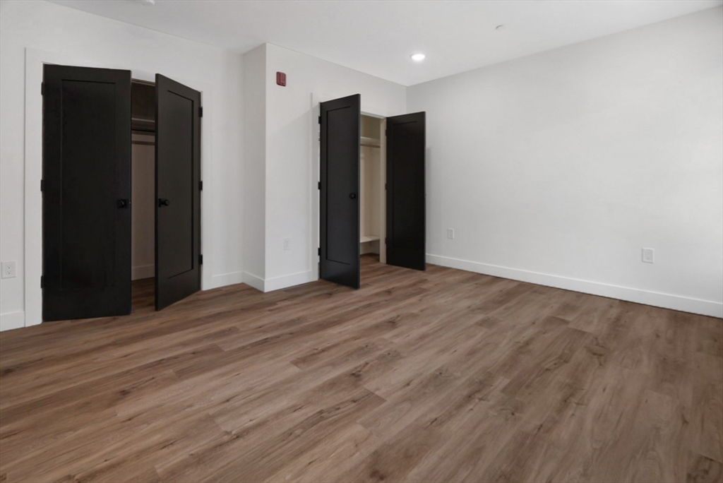 173 Magnolia Street, Unit 1 Boston, MA 02125 - Photo 4 of 9 a view of an empty room with wooden floor
