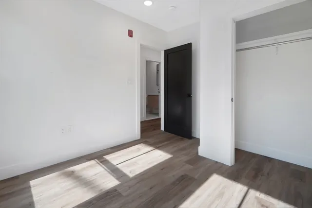 an empty room with wooden floor and closet