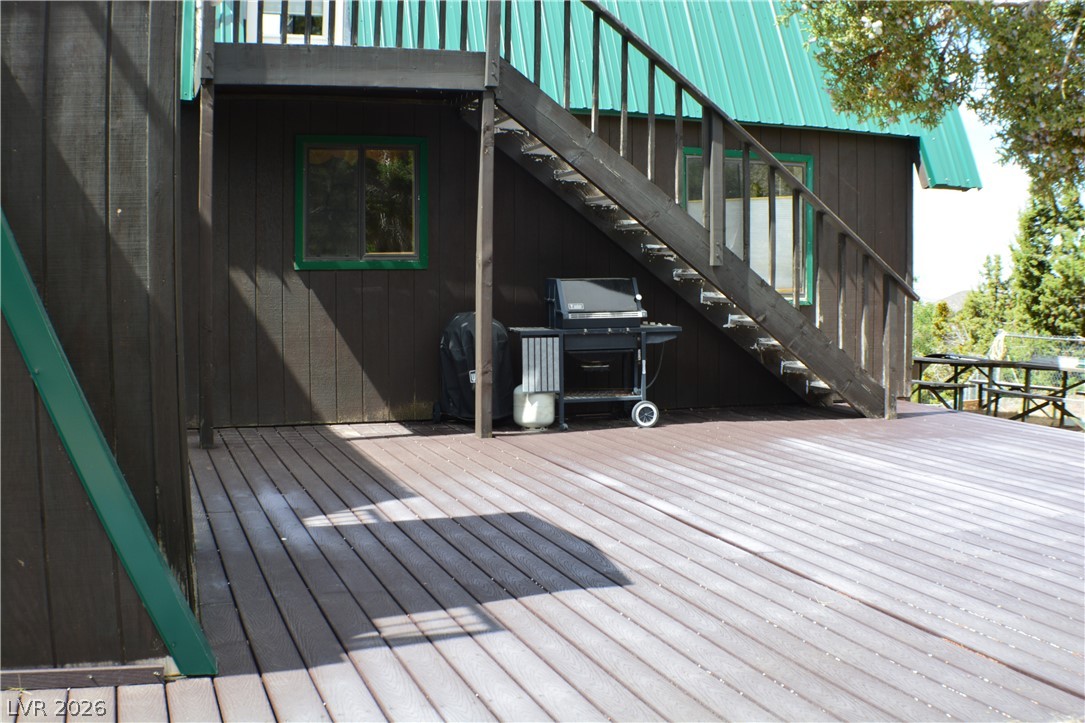 1321 Trout Canyon Road Las Vegas, NV 89124 - Photo 6 of 50 An inviting deck extends from a robust wood-sided structure, perfect for outdoor dining and entertaining.