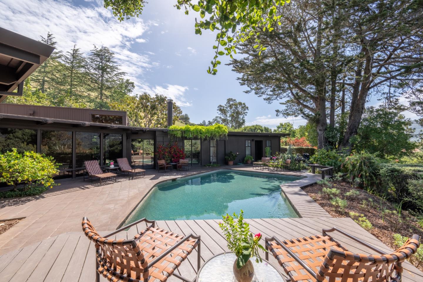 46 Middle Canyon Road Carmel Valley, CA 93924 - Photo 41 of 74 a view of a patio with couches table and chairs potted plants and a large tree