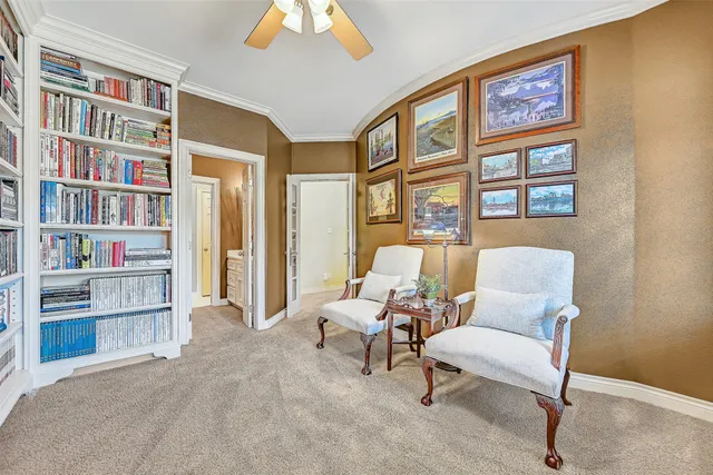 a living room with furniture a bookshelf and a large window