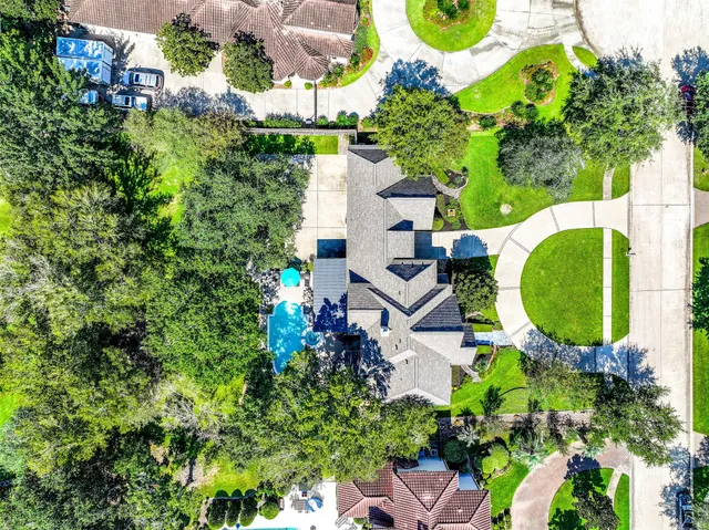 an aerial view of a house with swimming pool and garden
