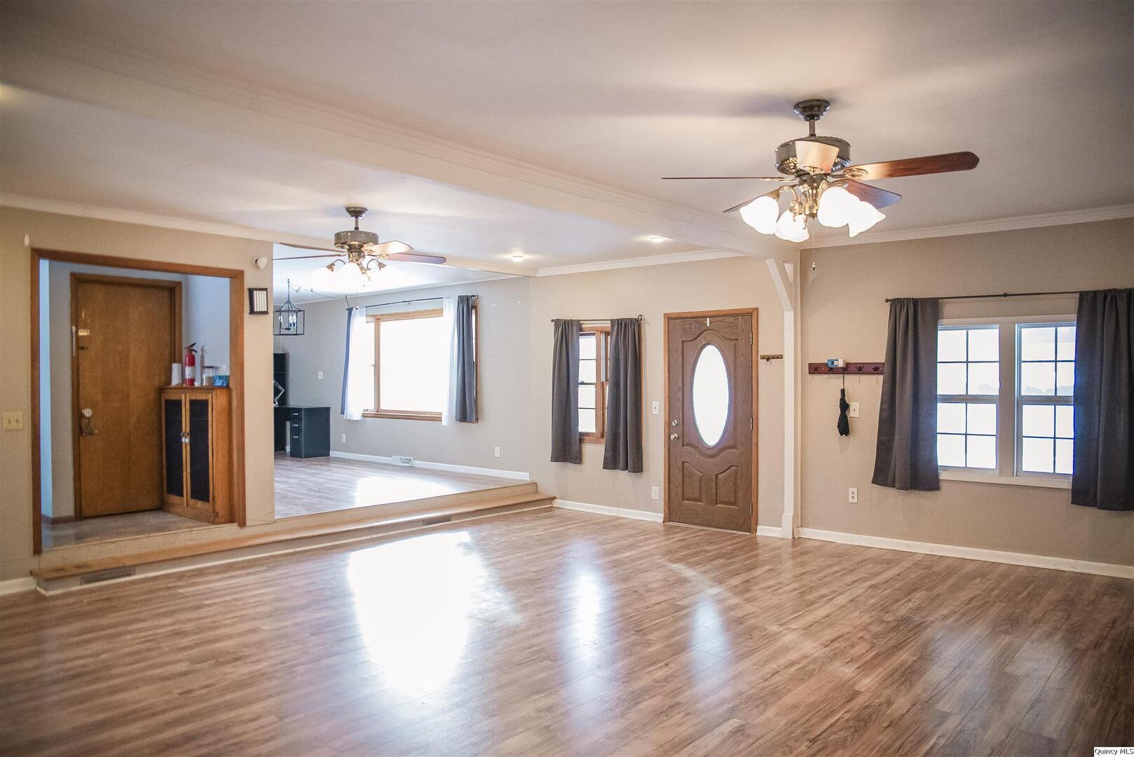 700 North 66th Street Quincy, IL 62305 - Photo 2 of 11 a view of an empty room with wooden floor and a ceiling fan