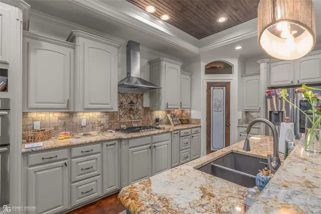 a kitchen with stainless steel appliances granite countertop a sink dishwasher and white cabinets with wooden floor