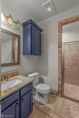 a bathroom with a granite countertop toilet sink and mirror