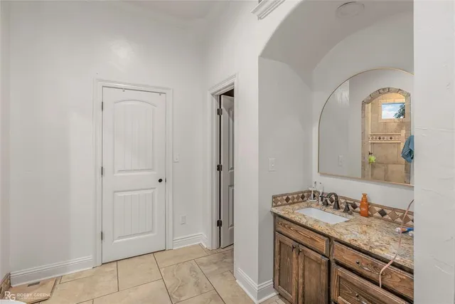 a bathroom with a granite countertop sink a mirror and a shower