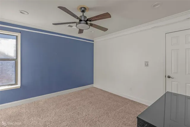 an empty room with a window and a fan
