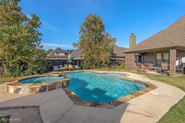 a view of a house with swimming pool and a yard