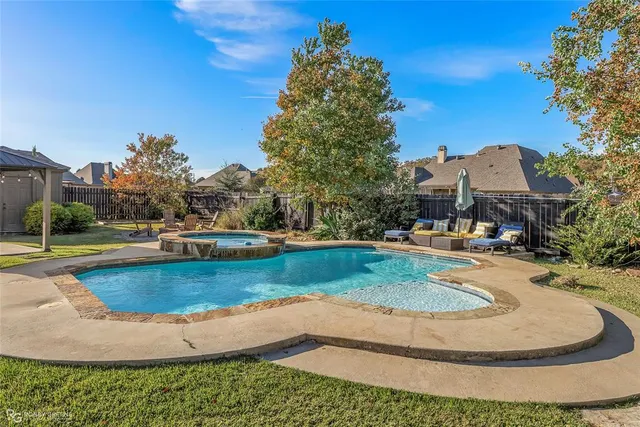 a view of a swimming pool with a yard