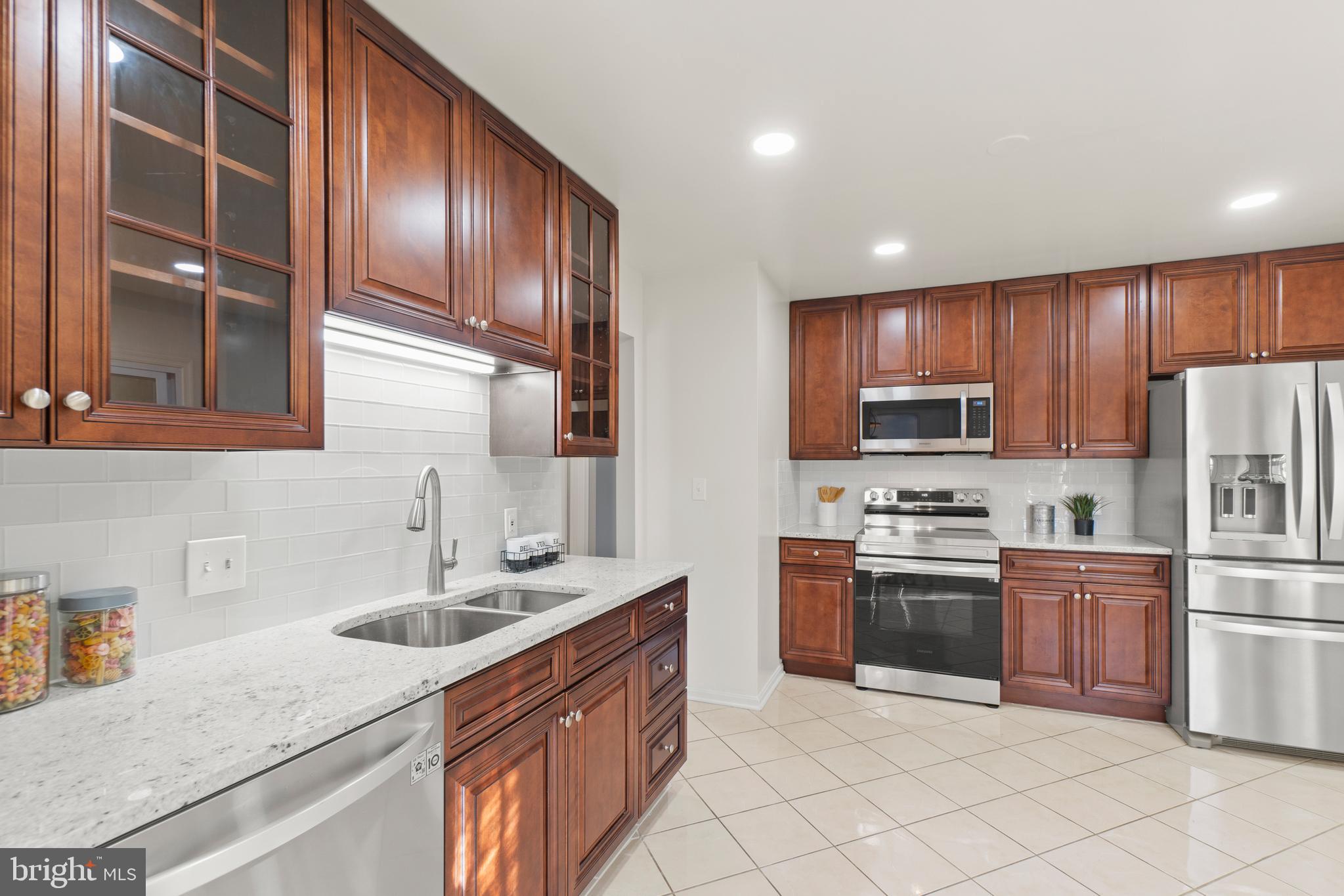 2430 Lyttonsville Road Silver Spring, MD 20910 - Photo 12 of 53 a kitchen with stainless steel appliances granite countertop a sink stove and refrigerator