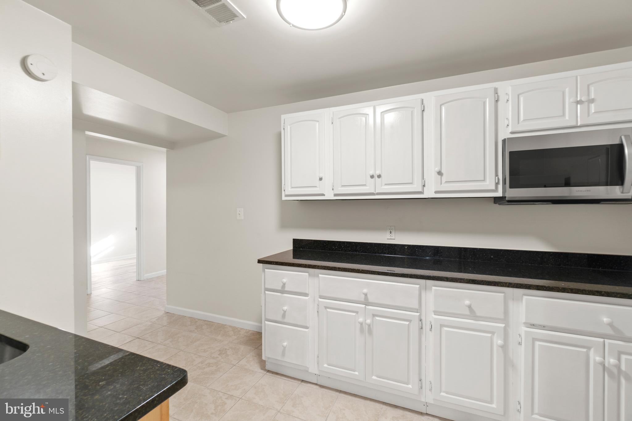 2430 Lyttonsville Road Silver Spring, MD 20910 - Photo 39 of 53 a kitchen with stainless steel appliances granite countertop white cabinets and a sink