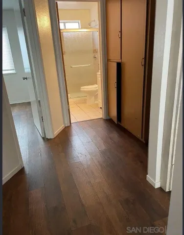 an empty room with wooden floor and entrance