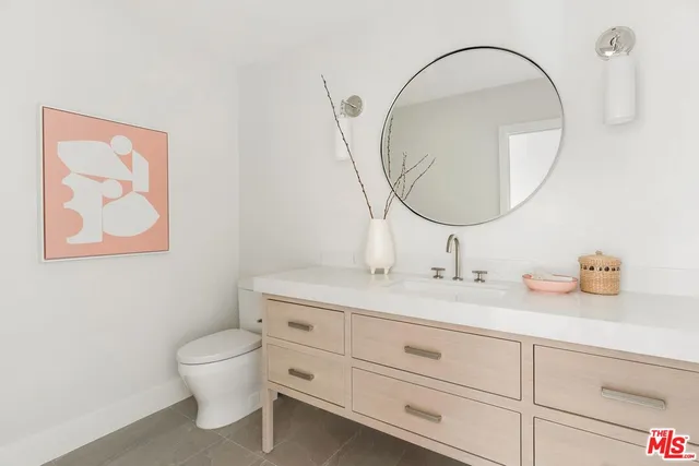 a bathroom with a granite countertop toilet a sink and a mirror
